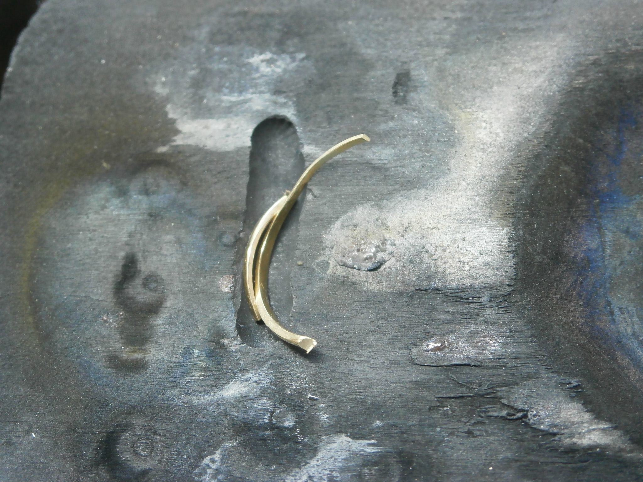 The shaft of the gold ring is placed into a small groove in a heat resistant charcoal block