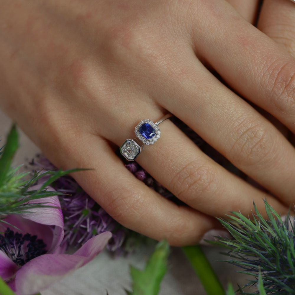 A stunning and truly elegant bright blue Ceylon Sapphire (approx. 0.62ct) cluster surrounded by brilliant cut Diamonds (approx. 0.12cts) and partnered beautifully with a gorgeous Radiant Cut Diamond (approx. 0.70cts) in 18ct white Gold, a contemporary statement model 2
